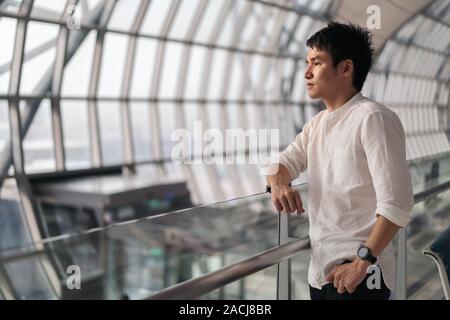 Giovane uomo in attesa del volo in aeroporto Foto Stock