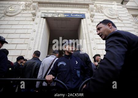 Algeri. 3 dicembre, 2019. Algerina di poliziotti e giornalisti si riuniscono al di fuori del Sidi Mhamed corte ad Algeri, Algeria il 2 dicembre, 2019. Un algerino tribunale lunedì ha rinviato il processo di un caso di corruzione che coinvolgono ex primi ministri, compresi Ahmed Ouyahia e Abdelmalek Sellal, su una difesa, media ufficiali segnalati. La Corte di Sidi Mhamed ad Algeri era affollata da cittadini e giornalisti che è venuto a partecipare a questo mega-trial, in seguito alla decisione delle autorità di tollerare l accesso del pubblico. Credito: Xinhua/Alamy Live News Foto Stock