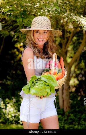 La frutta e la verdura in un cestello con una donna Foto Stock