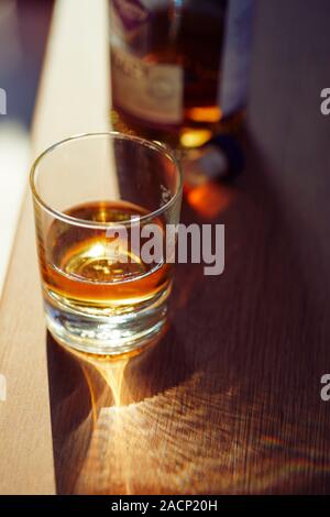 Bicchiere di whisky e una bottiglia Foto Stock