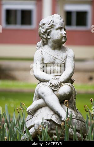 Statua di un giovane bambino in un parco urbano Foto Stock