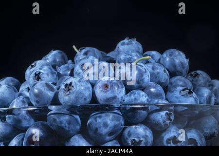 Odessa, Ucraina, l'Europa orientale. 6 Luglio, 2019. Mirtilli freschi in vetreria su sfondo nero. Close-up di Bog mirtillo, bog mirtillo, northern mirtillo o western mirtillo Credito: Andrey Nekrasov/ZUMA filo/Alamy Live News Foto Stock