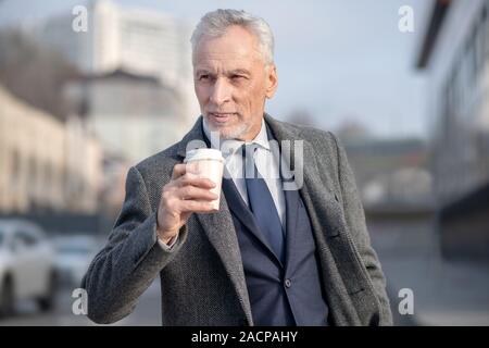 Uomo maturo in elegante rivestimento avente il caffè Foto Stock