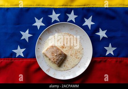 "Tres Leches torta" sulla parte superiore della bandiera venezuelana, un tradizionale dessert venezuelano con latte e cannella in polvere, simbolo dell'america latina cucina Foto Stock
