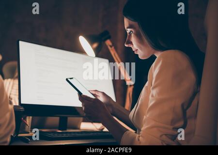 Profilo vista laterale ritratto di lei bella attraente piuttosto concentrati concentrati lady analista analizzando i dati di ricerca la scrittura di sms di notte Foto Stock