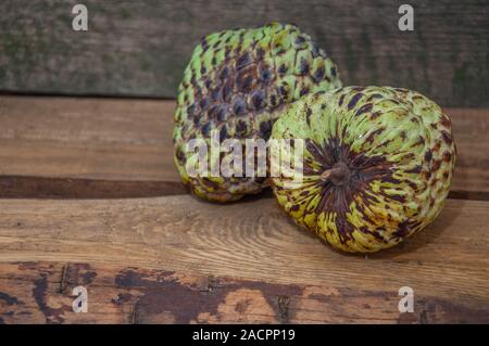 Cherimoya frutta sul tavolo di legno dello sfondo. Due cherimoyas. Close up,Annona cherimola Foto Stock