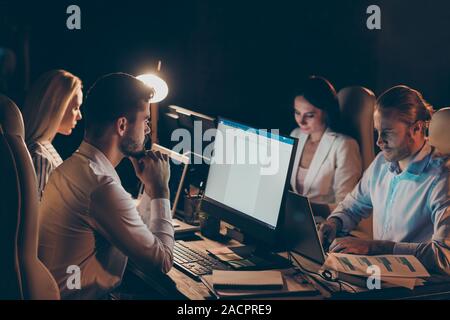 Ritratto di Nizza attraente concentrati concentrati i colleghi di lavoro raccolta preparazione del report ricercando i dati finanziari analizzando la notte preparazione del report Foto Stock