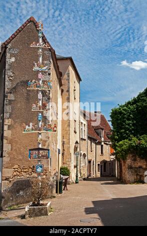 Strada locale con un polo decorata con sculture in legno che mostrano scene medievali, Le Blanc town, Indre (36), Center-Val de regione della Loira, Francia Foto Stock