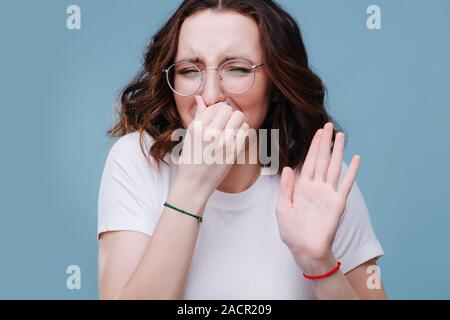 Odore di qualcosa di maleodorante e brutte, ella apnea con le dita sul naso Foto Stock