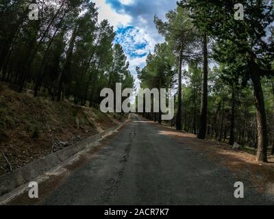 POV guida su una strada di montagna molto lentamente tra la vegetazione locale. Una unità di auto attraverso la montagna su Nerpio's road, Spagna su un giorno nuvoloso. Foto Stock