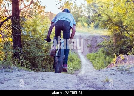Atleta ciclista, corse su una strada nella foresta. Escursioni in bicicletta Foto Stock
