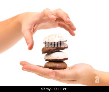 Mano trattiene pila di meringhe al cioccolato. Foto Stock