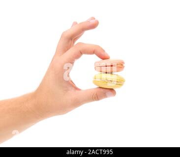 Mano trattiene macarons. Foto Stock