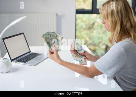 Donna che mantiene Polski Polish Zloty PLN e le banconote in euro in mani. Euro denaro e Polski Polish Zloty PLN in un womans mani su uno sfondo bianco. Di euro in Polonia. Foto Stock