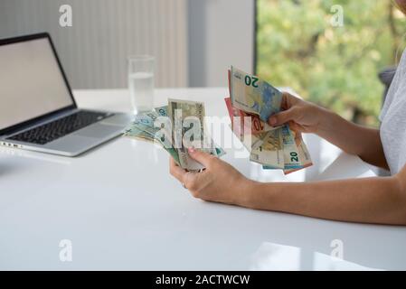 Donna che mantiene Polski Polish Zloty PLN e le banconote in euro in mani. Euro denaro e Polski Polish Zloty PLN in un womans mani su uno sfondo bianco. Di euro in Polonia. Foto Stock