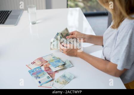 Donna che mantiene Polski Polish Zloty PLN e le banconote in euro in mani. Euro denaro e Polski Polish Zloty PLN in un womans mani su uno sfondo bianco. Di euro in Polonia. Foto Stock