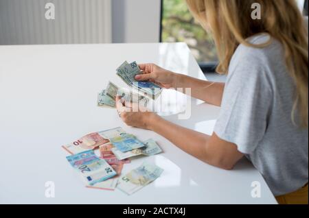 Donna che mantiene Polski Polish Zloty PLN e le banconote in euro in mani. Euro denaro e Polski Polish Zloty PLN in un womans mani su uno sfondo bianco. Di euro in Polonia. Foto Stock