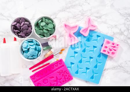 Lay piatto. Ingredienti per fare il cioccolato mermaid stampi da scaglie di cioccolato. Foto Stock