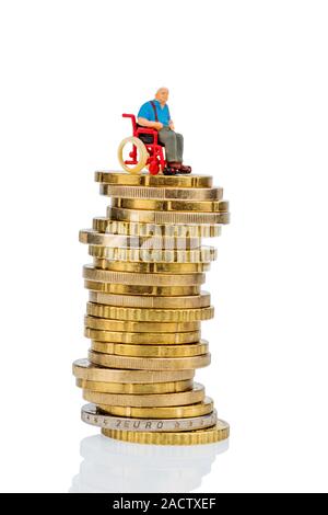 Una donna su una sedia a rotelle su un mucchio di soldi Foto Stock