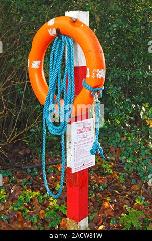 Un lifebelt e avviso pubblico dal pool di mulino sul fiume Bure a Guildford, Norfolk, Inghilterra, Regno Unito, Europa. Foto Stock