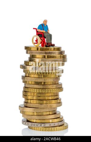 Una donna su una sedia a rotelle su un mucchio di soldi Foto Stock