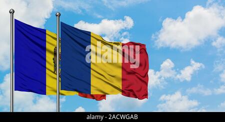 La Moldavia e la Romania bandiera sventolare nel vento contro bianco torbido cielo blu insieme. Concetto di Diplomazia e relazioni internazionali. Foto Stock