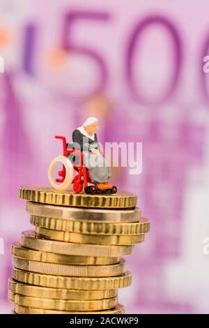 Una donna su una sedia a rotelle su un mucchio di soldi Foto Stock