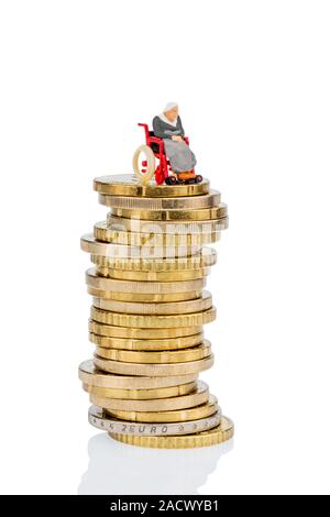 Una donna su una sedia a rotelle su un mucchio di soldi Foto Stock