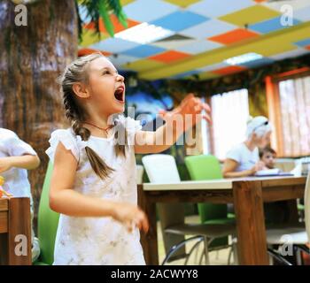 Bambina facendo una faccia buffa.il concetto del gioco. Foto Stock