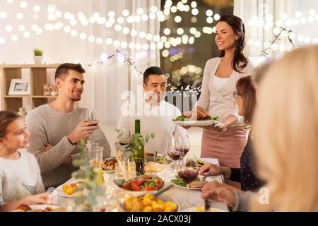 Celebrazione, vacanze e concetto di persone - famiglia felice avente pollo arrosto per cena a casa Foto Stock