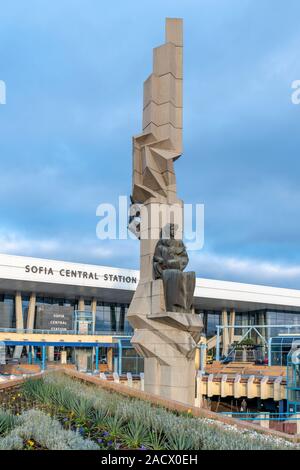 Sofia Central Station con era Sovietica scultura nel centro di una piazza circolare. Aperto nel 1974, la stazione è stata progettata da architetto Milko Bechev. Foto Stock