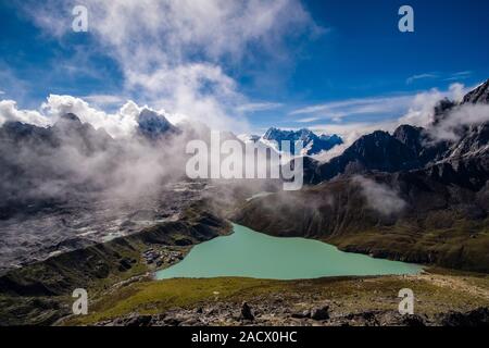 Antenna di panoramica vista sul lago di Gokyo, Ngozumpa glacier e il villaggio dal vertice di Gokyo Ri, monsone di nuvole che si muovono in Foto Stock