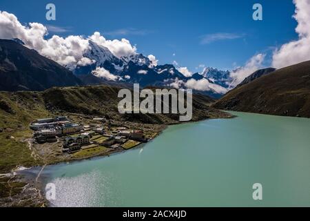 Antenna di panoramica vista sul lago di Gokyo e il villaggio da Gokyo Ri, i vertici di Mt. Cholatse, Mt. Taboche e Mt. Tamserku nella distanza Foto Stock