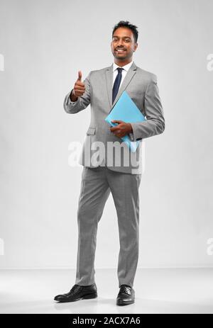Il lavoro in ufficio il lavoratore e il concetto di persone - sorridente commerciante indiano in camicia con cravatta che mostra Thumbs up su sfondo grigio Foto Stock