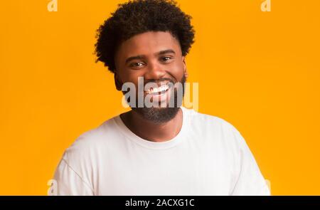 Allegro uomo nero ridere su sfondo arancione Foto Stock