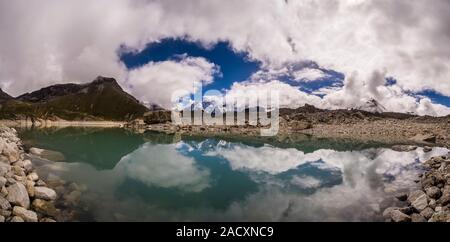 Vista panoramica su 5a Gokyo lago a nord, Mt. Gyazung Kang coperto dal monsone di nuvole a distanza Foto Stock
