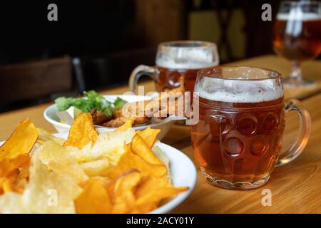 Boccale di birra con birra e spuntini. Corn chips con salsa a base di pesce e verdure. Foto Stock