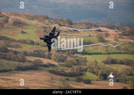 F-15 Eagle, USAF Mc Donnell Douglas caccia a basso livello che vola da Valley Anglesey attraverso il Mach Loop in Cadair Idris Wales Foto Stock