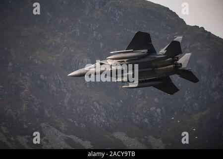 F-15 Eagle, USAF Mc Donnell Douglas caccia a basso livello che vola da Valley Anglesey attraverso il Mach Loop in Cadair Idris Wales Foto Stock