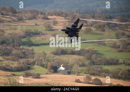 F-15 Eagle, USAF Mc Donnell Douglas caccia a basso livello che vola da Valley Anglesey attraverso il Mach Loop in Cadair Idris Wales Foto Stock