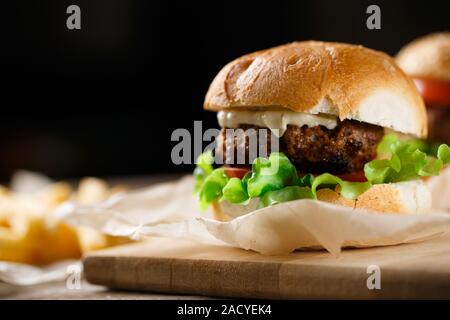 In casa gustosi hamburger e patatine fritte sul tavolo di legno Foto Stock