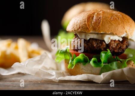 In casa gustosi hamburger e patatine fritte sul tavolo di legno Foto Stock