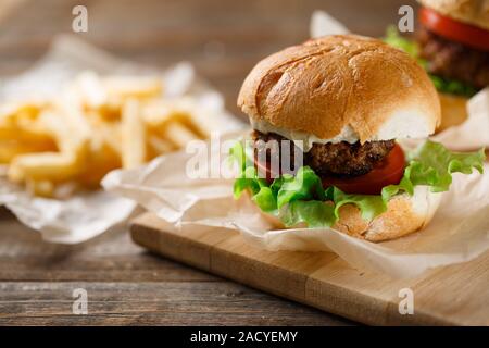In casa gustosi hamburger e patatine fritte sul tavolo di legno Foto Stock