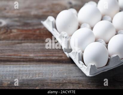 Le uova bianche su una tavola in legno rustico Foto Stock