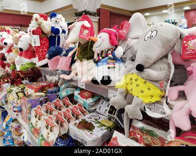 Ekaterinburg, Russia - Novembre,25,2019: sacco di giocattoli morbidi e imballaggi colorati con dolci regali di Natale su scaffali in grande supermercato. Foto Stock