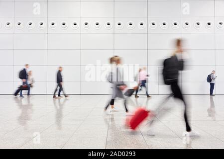 Anonimo sfocato chi viaggia nella hall dell'aeroporto Foto Stock