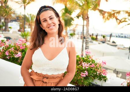 Giovane bella donna sorridente felice camminando sulle strade della città di Puerto de la Cruz Tenerife da una giornata di sole di estate Foto Stock