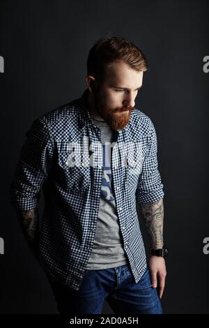Malinconici rosso uomo barbuto ritratto in studio su sfondo scuro Foto Stock