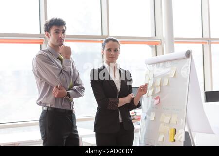 Coppia giovane lavorando sul flip board in ufficio Foto Stock