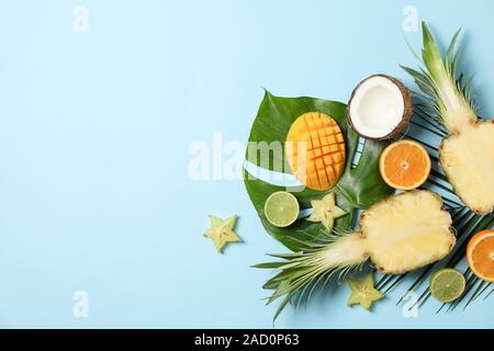 Frutti Esotici e foglie di palmo su sfondo blu, spazio per il testo Foto Stock